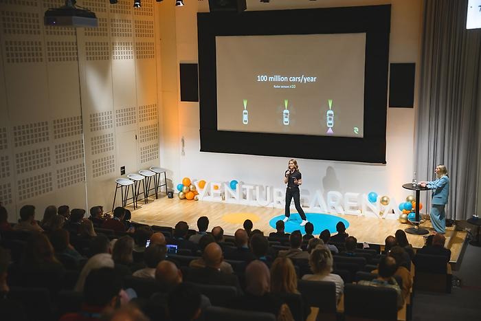 Frida Wygler standing on a stage giving a lecture.