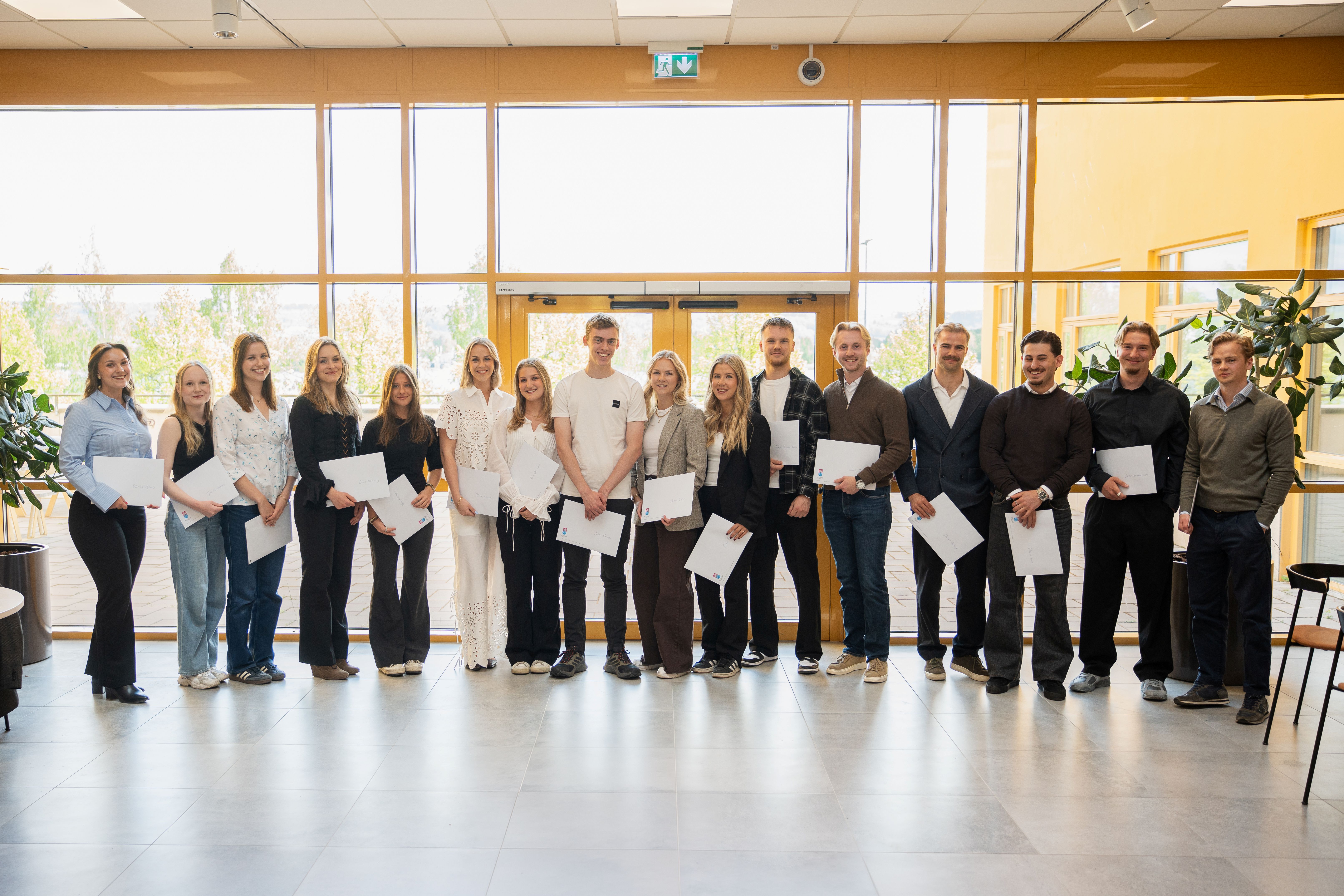 Gruppfoto på studenter med diplom