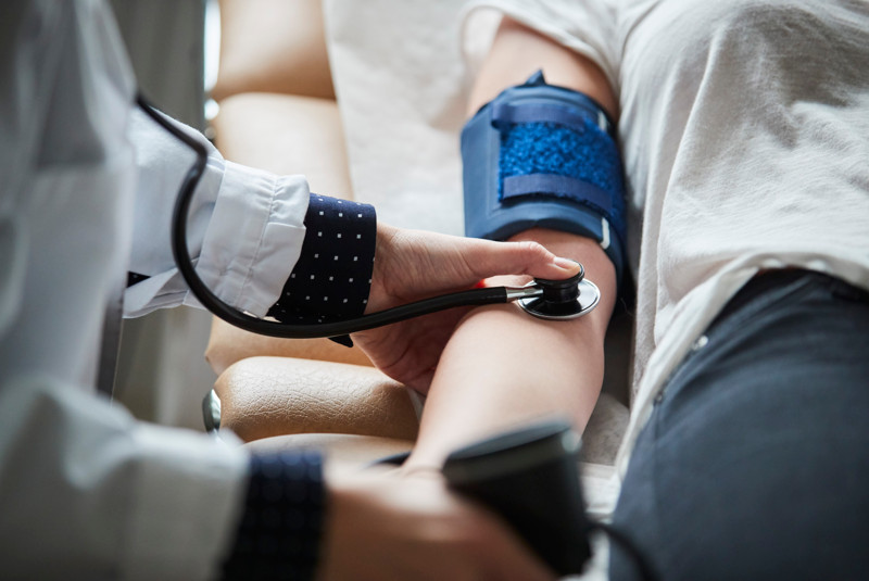 En person med gips på armen som håller i ett stetoskop.