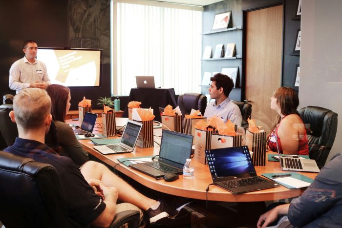 people around table with laptops